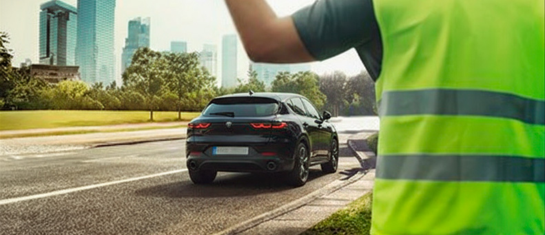 Roadside technician fitting a new car battery to a Alfa Romeo
