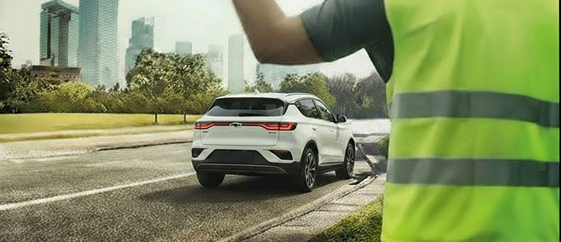 Roadside technician fitting a new car battery to a Chevrolet