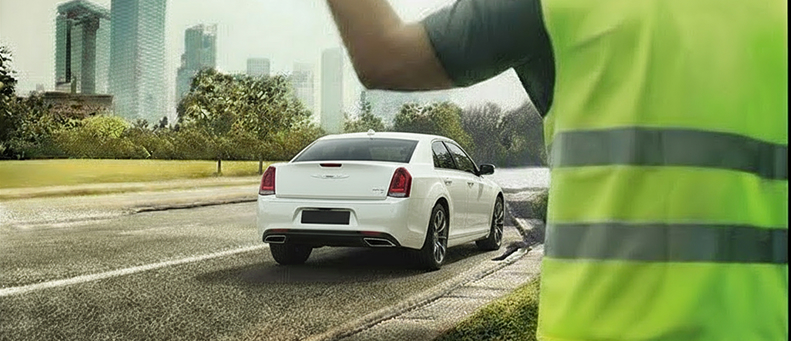 Roadside technician fitting a new car battery to a Citroen