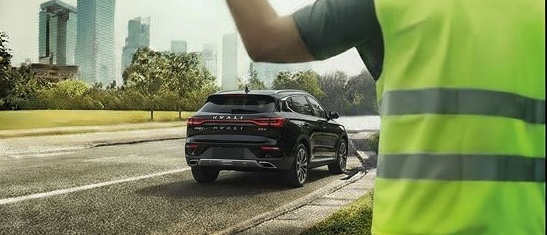 Roadside technician fitting a new car battery to a Haval