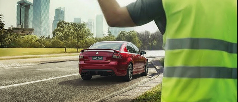 Roadside technician fitting a new car battery to a HSV