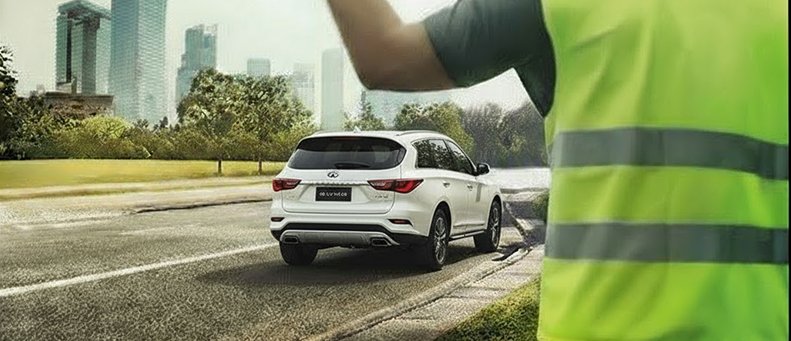Roadside technician fitting a new car battery to a Infiniti