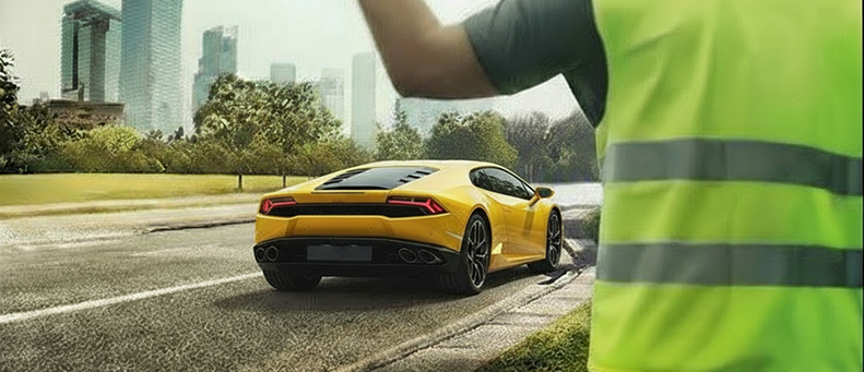 Roadside technician fitting a new car battery to a Lamborghini