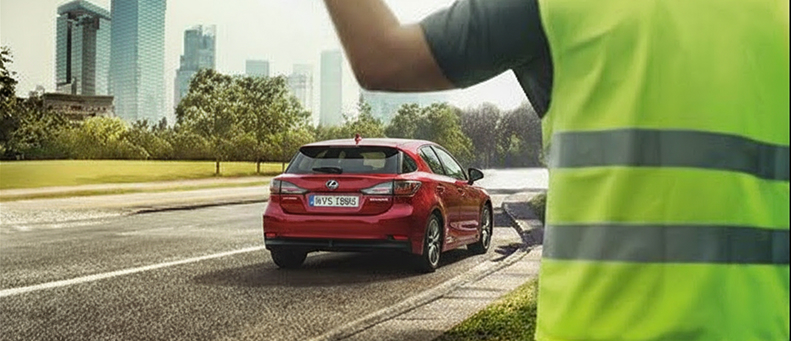 Roadside technician fitting a new car battery to a Lexus