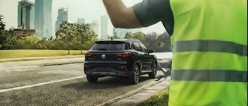 Roadside technician fitting a new car battery to a MG