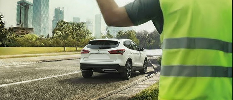 Roadside technician fitting a new car battery to a Nissan
