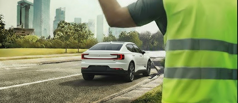 Roadside technician fitting a new car battery to a Polestar