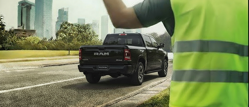 Roadside technician fitting a new car battery to a RAM