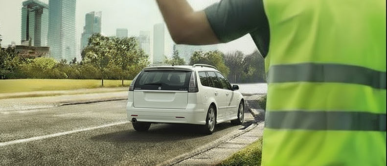 Roadside technician fitting a new car battery to a Saab