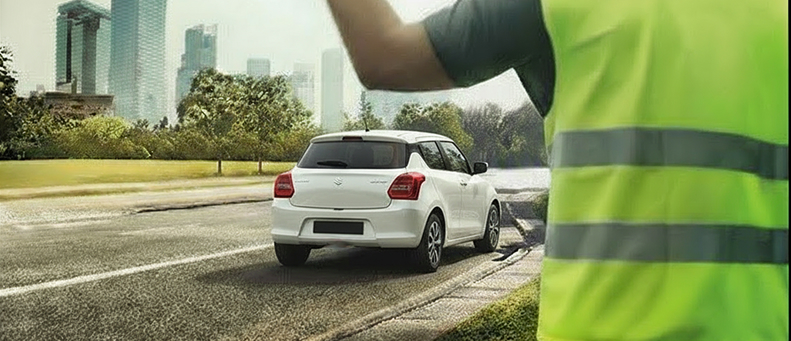 Roadside technician fitting a new car battery to a Suzuki